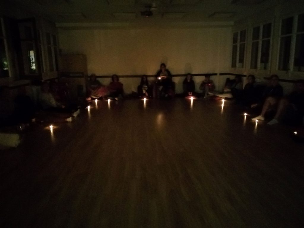 Participantes del Retiro de Silencio reunidos en círculo con velas en la sala