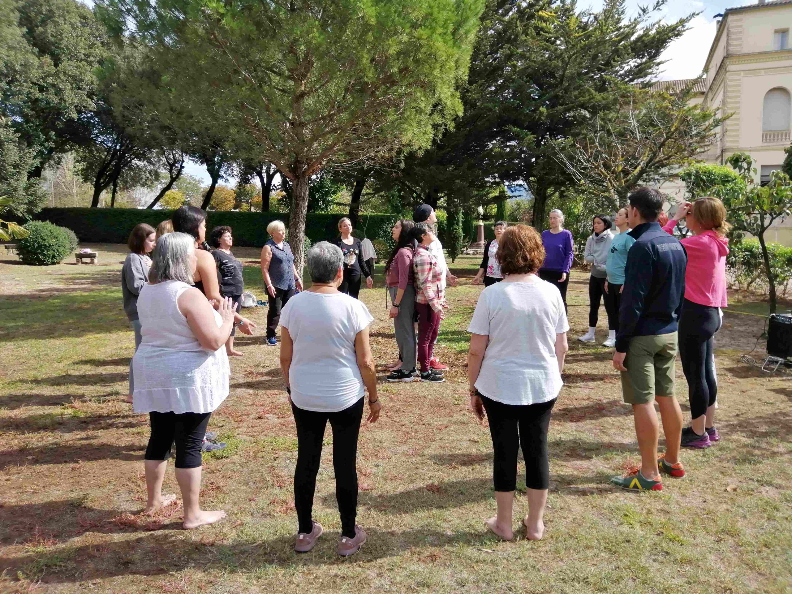 Participantes reunidos en círculo en el jardín