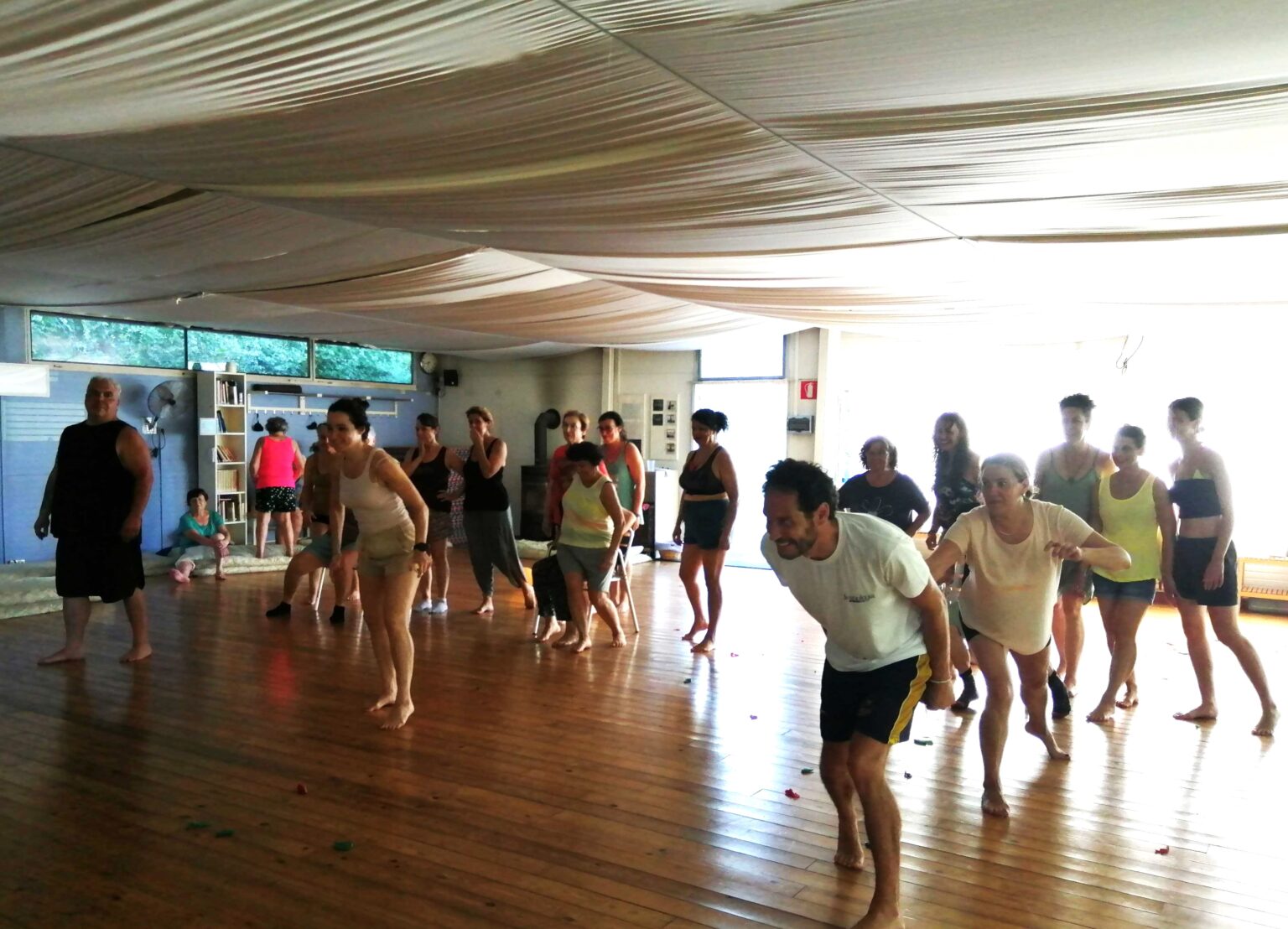 Participantes en una práctica de movimiento en la sala del Retiro de Alegría