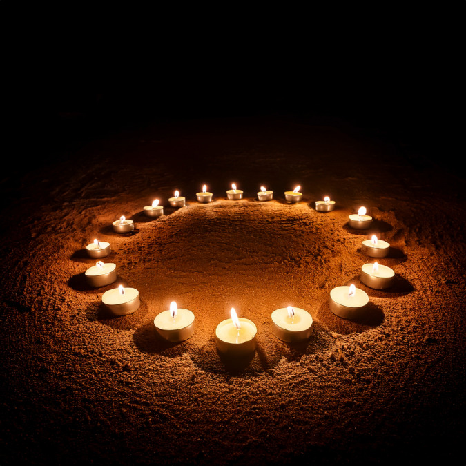 Velas encendidas dispuestas en círculo en la oscuridad