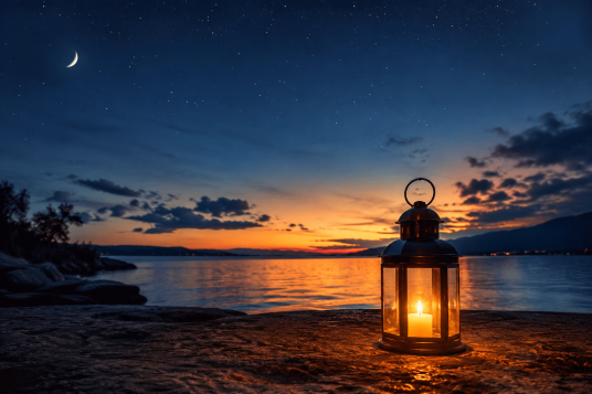 Un farol encendido junto a un lago al anochecer